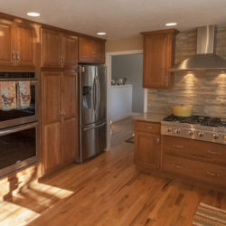 Kitchen cherry cabinetry with wood floors in whole house remodel
