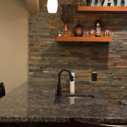 Aurora, Colorado basement finish with stacked stone bar wall open shelving