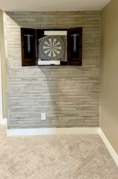 A dartboard mounted inside a recessed dark alcove or cabinet